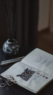 Artistic Owl Sketch in Open Notebook on Dark Desk Wallpaper