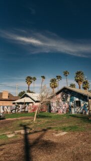 Urban Street Art House with Palm Trees Under Deep Blue Sky Wallpaper