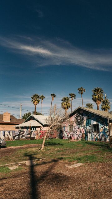 Urban Street Art House with Palm Trees Under Deep Blue Sky Wallpaper
