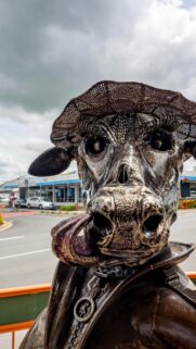 Unique Metal Cow Sculpture Wearing a Hat Mobile Wallpaper