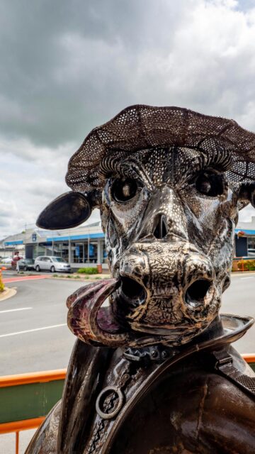 Unique Metal Cow Sculpture Wearing a Hat Mobile Wallpaper