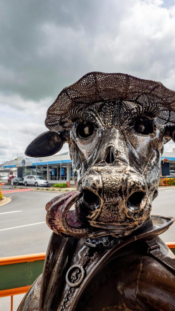 Unique Metal Cow Sculpture Wearing a Hat Mobile Wallpaper