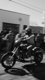 Black and White Motorcycle Rider Speeding Through Street Wallpaper