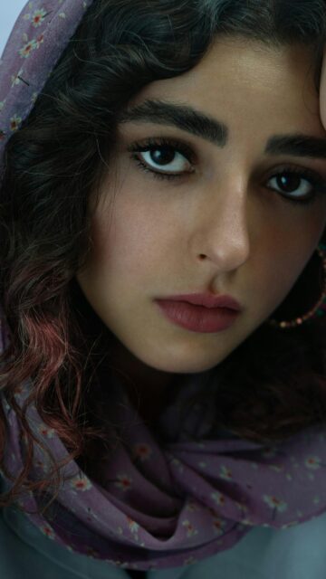 Stunning Portrait of a Young Woman with Curly Hair Phone Wallpaper