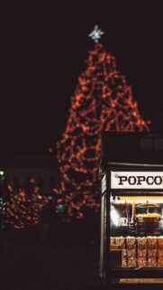 Festive Christmas Tree and Popcorn Stand Night Mobile Wallpaper