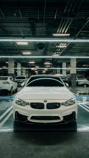 Stunning White BMW M3 Sport Sedan in Modern Parking Garage Mobile Wallpaper