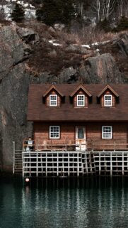 Rustic Cabin on Stilts Over Dark Calm Waters Phone Wallpaper
