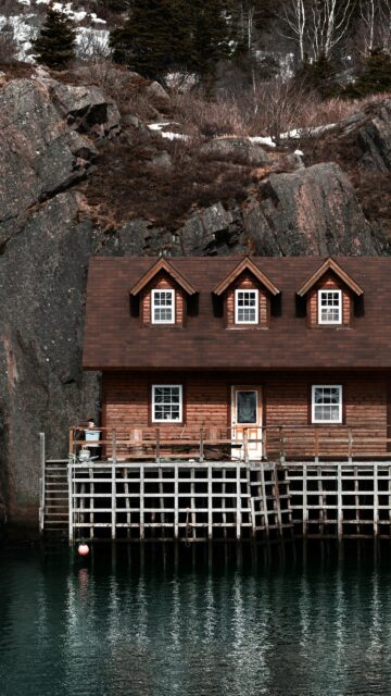 Rustic Cabin on Stilts Over Dark Calm Waters Phone Wallpaper