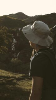 Adventurous Hiker Gazing at Mountain Waterfall Phone Wallpaper