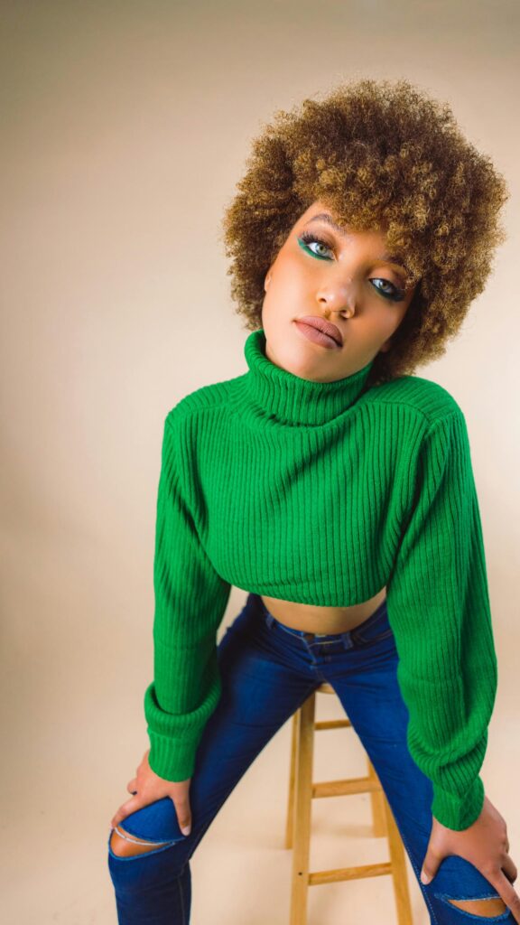 Stylish Woman in Green Crop Sweater with Afro Hairstyle Portrait Wallpaper