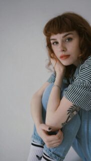 Stunning Ginger Girl with Short Bangs and Tattoo Portrait Wallpaper