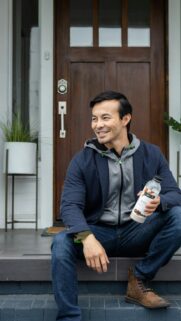 Stylish Man Sitting on Porch with Healthy Meal Shake Wallpaper