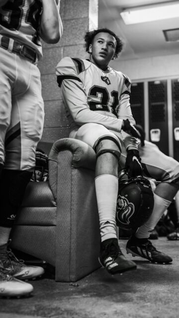 American Football Player Focused in Locker Room Portrait Wallpaper