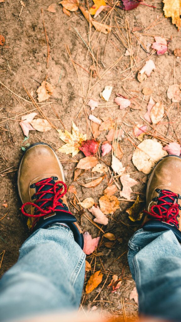 First-Person POV Hiking Boots on Autumn Trail Fall Season Wallpaper