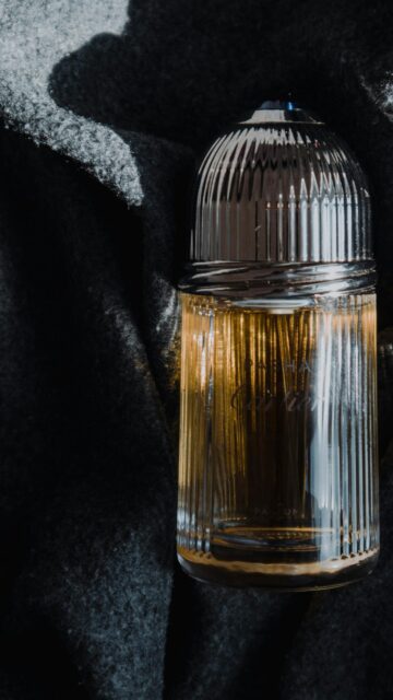 Luxury Cartier Pasha Parfum Bottle on Dark Fabric Phone Wallpaper