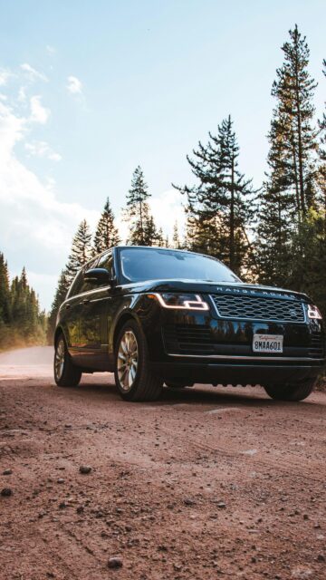 Black Range Rover SUV on Dirt Road Forest Path Phone Wallpaper