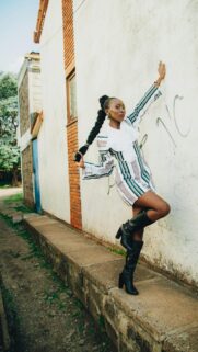 Chic African Fashionista Posing in Striped Dress Mobile Wallpaper