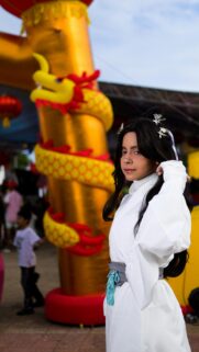 Cosplay Girl in Traditional White Asian Attire with Golden Dragon Wallpaper