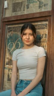 Young Woman Posing Before Vintage Newspaper Window Portrait Wallpaper