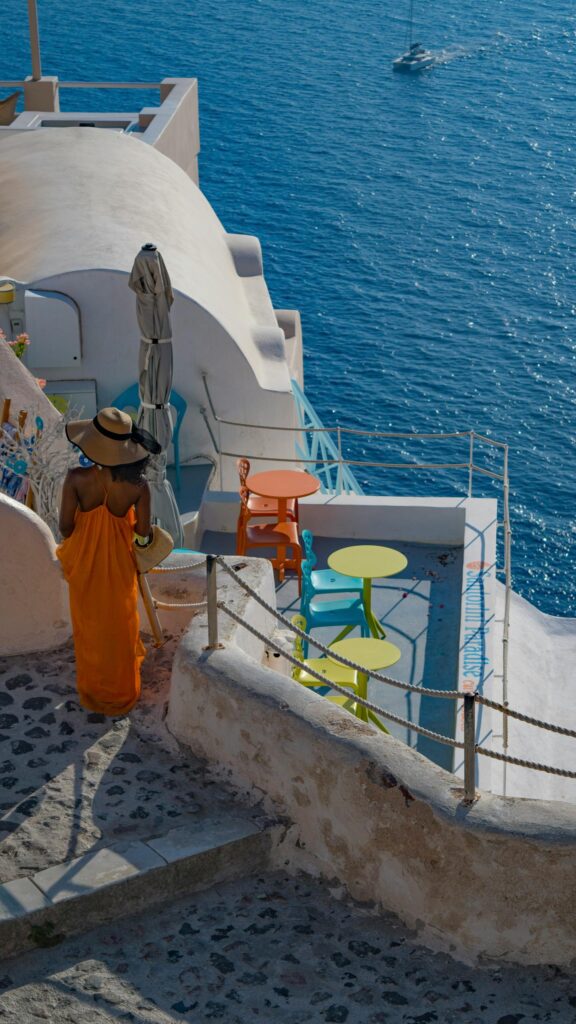 Woman in Orange Dress Santorini Terrace View Phone Wallpaper