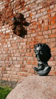 Mystical Bronze Goblin Statue on Stone Wall Background Wallpaper