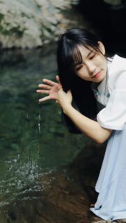 Serene Asian Girl Touching Water in Nature Mobile Wallpaper