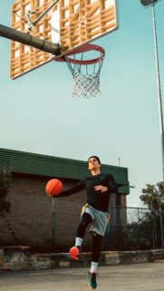 Young Basketball Player Jumping for a Dunk Mobile Wallpaper