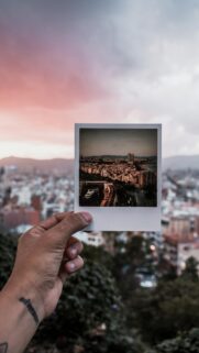 Hand Holding Polaroid Cityscape View Over Barcelona Sunset Wallpaper