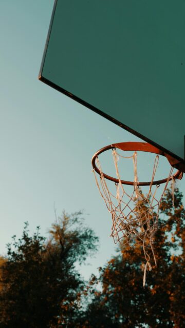 Golden Hour Basketball Hoop Against Clear Blue Sky Mobile Wallpaper