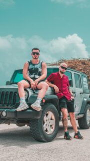 Two Stylish Men Posing on a Silver Jeep SUV 4K Mobile Wallpaper
