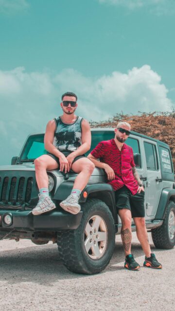 Two Stylish Men Posing on a Silver Jeep SUV 4K Mobile Wallpaper
