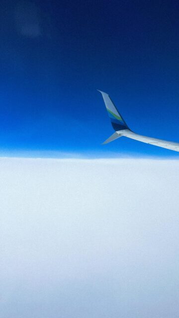 Minimalist Airplane Wing Above Cloud Sea and Deep Blue Sky Wallpaper
