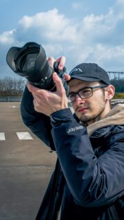 Professional Photographer with Camera Outdoors Portrait Wallpaper