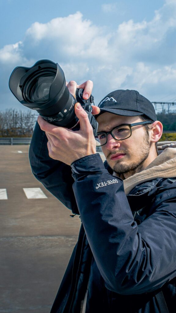 Professional Photographer with Camera Outdoors Portrait Wallpaper