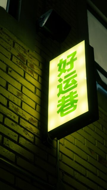 Glowing Green Chinese Neon Sign on Brick Wall Night Wallpaper