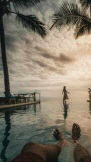 Stunning Infinity Pool Sunset with Woman Silhouette Phone Wallpaper