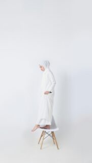 Minimalist Woman in White Hijab Standing on a Chair Wallpaper