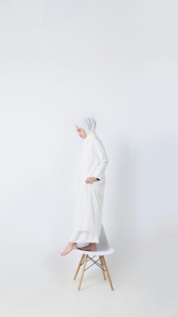 Minimalist Woman in White Hijab Standing on a Chair Wallpaper