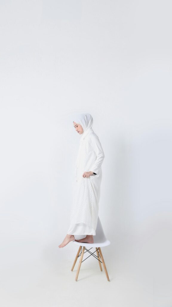 Minimalist Woman in White Hijab Standing on a Chair Wallpaper