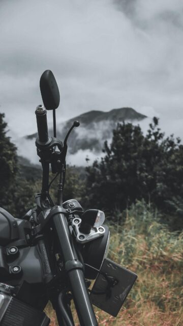 Motorcycle Handlebar View with Misty Mountain Peak Mobile Wallpaper