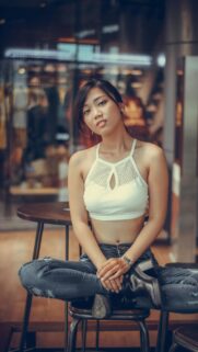 Beautiful Asian Girl Sitting on Stool in Stylish Crop Top Wallpaper