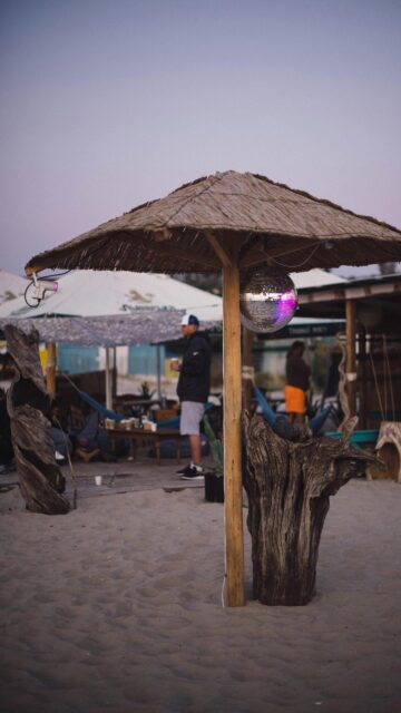 Relaxing Beach Bar Vibes with Disco Ball Sunset Background Wallpaper