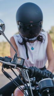 Biker Girl in Matte Black Helmet on Royal Enfield Motorcycle Wallpaper