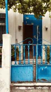 Charming Blue Door and Ornate Iron Gate Mediterranean House Wallpaper