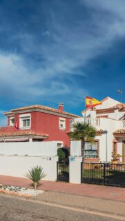 Spanish Villa with Flag Under Bright Blue Sky Mobile Wallpaper