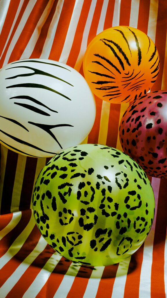 Vibrant Animal Print Balloons on Striped Background Mobile Wallpaper