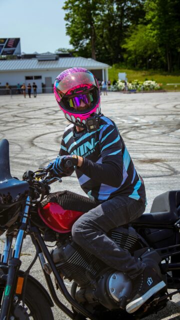 Stunt Rider in Vibrant Pink Monster Helmet on Motorcycle Wallpaper