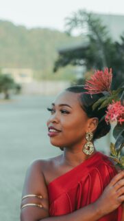 Elegant Woman in Red Satin Dress with Tropical Flowers Wallpaper