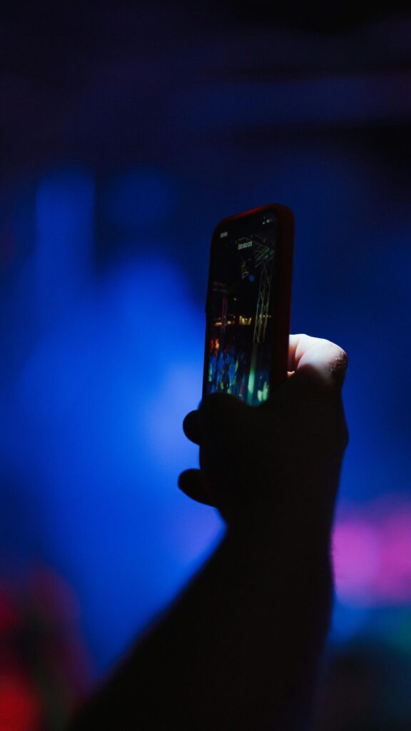 A Person Recording a Concert on Their Smartphone Mobile Wallpaper
