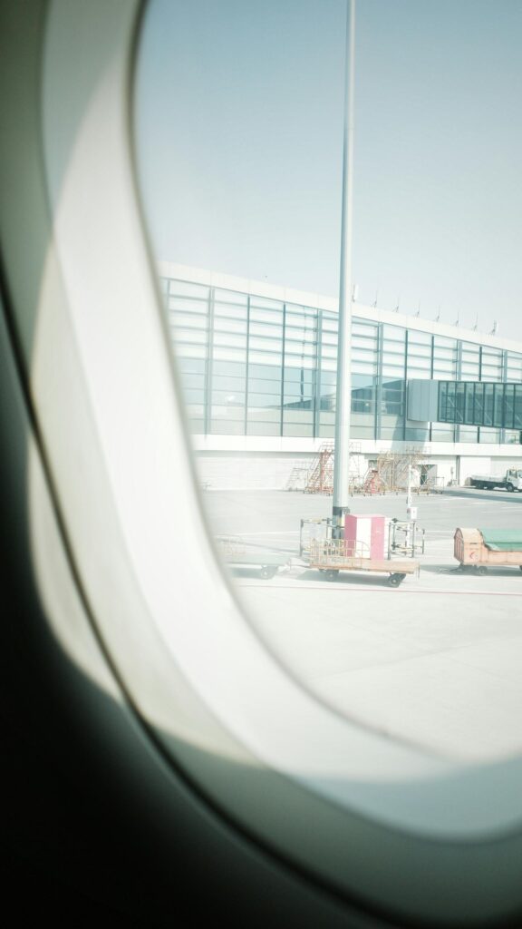 Airplane Window View of Sunny Airport Terminal Tarmac Wallpaper